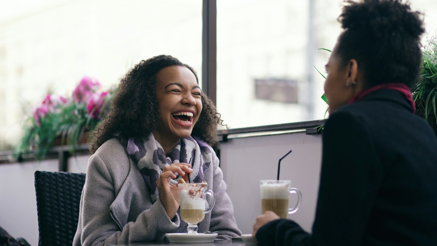 Two friends sharing a joyful conversation